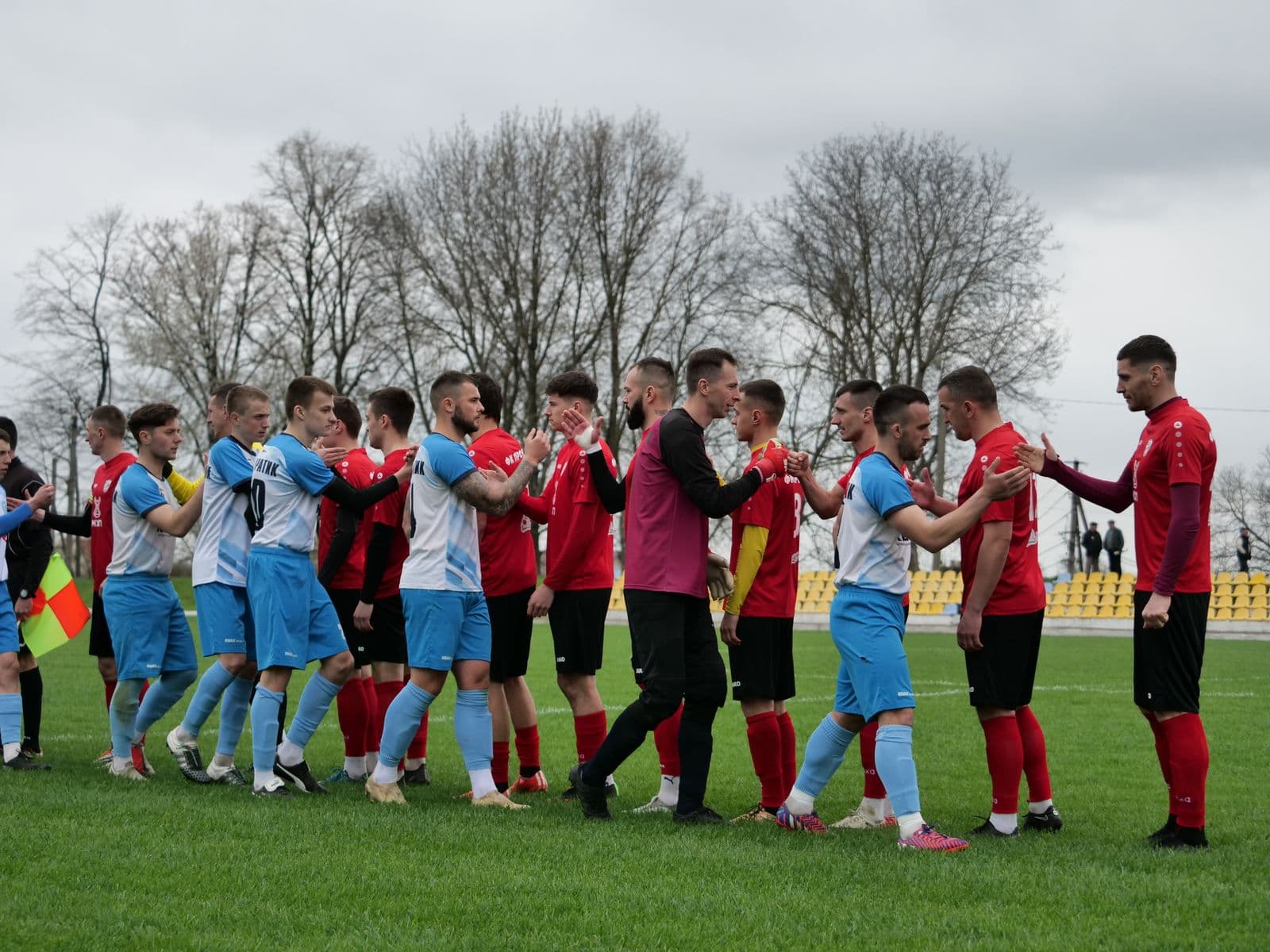Two teams shaking hands before a friendly match